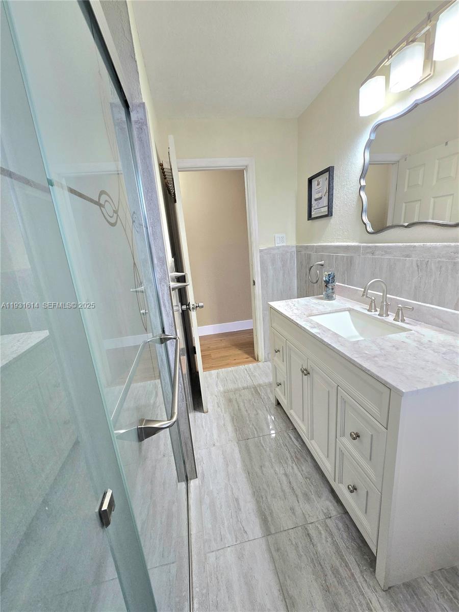 13340 Northeast 16th Avenue North Miami, FL 33161 - Photo 5 of 18 a bathroom with a double vanity sink and a mirror