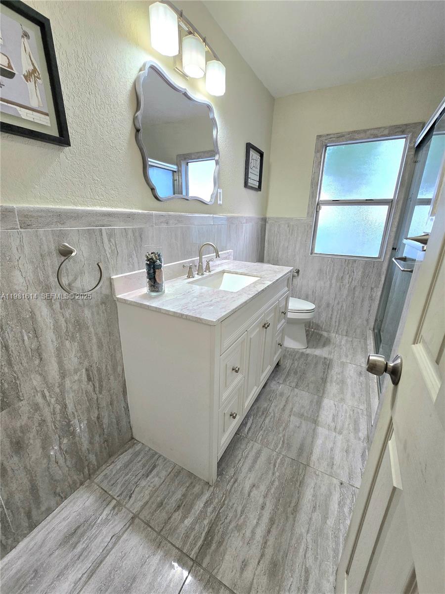 13340 Northeast 16th Avenue North Miami, FL 33161 - Photo 6 of 18 a bathroom with a double vanity sink mirror and bathtub