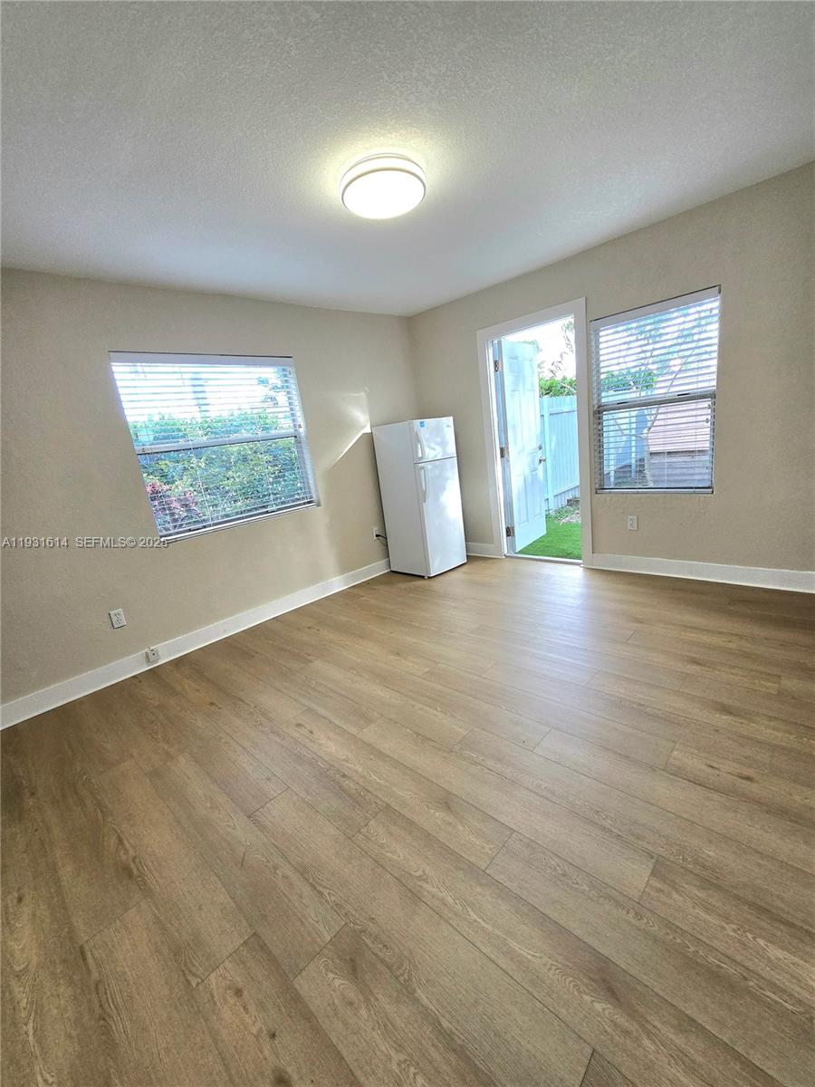 13340 Northeast 16th Avenue North Miami, FL 33161 - Photo 7 of 18 an empty room with wooden floor and windows