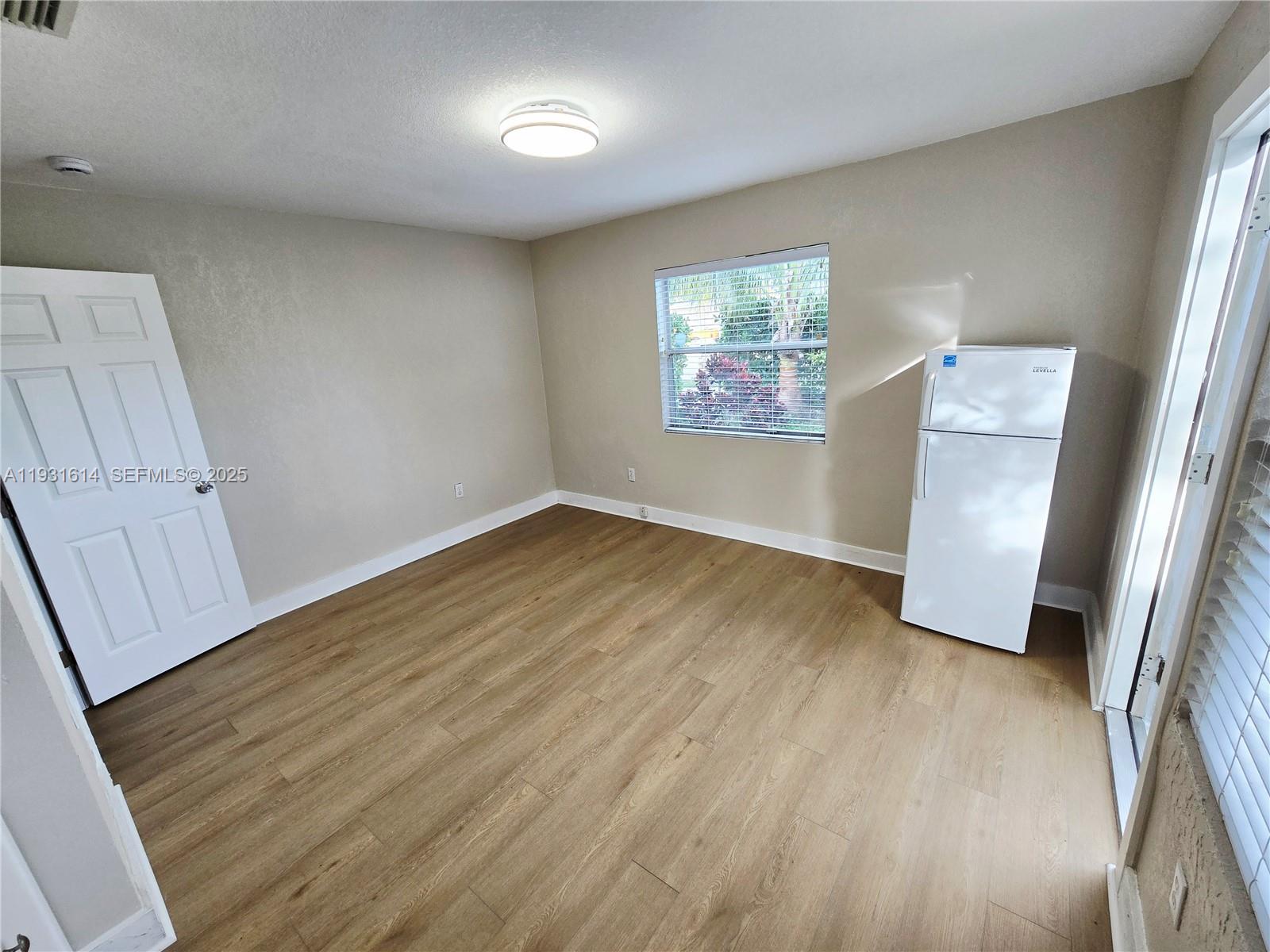 13340 Northeast 16th Avenue North Miami, FL 33161 - Photo 8 of 18 wooden floor in an empty room with a window