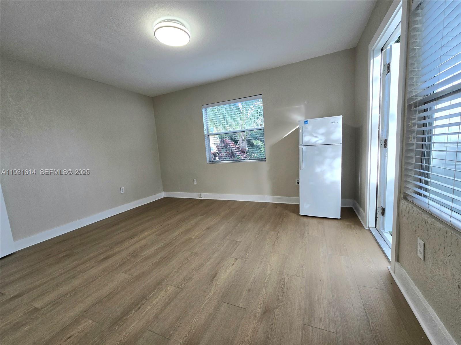 13340 Northeast 16th Avenue North Miami, FL 33161 - Photo 9 of 18 an empty room with wooden floor and windows