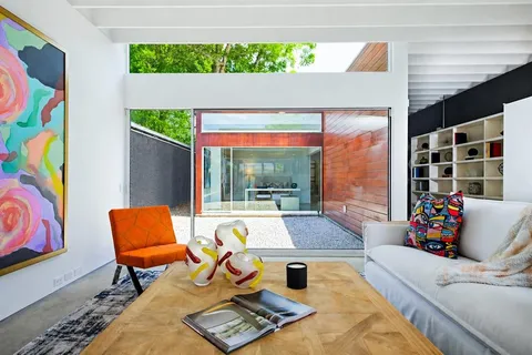 a living room with furniture and a floor to ceiling window