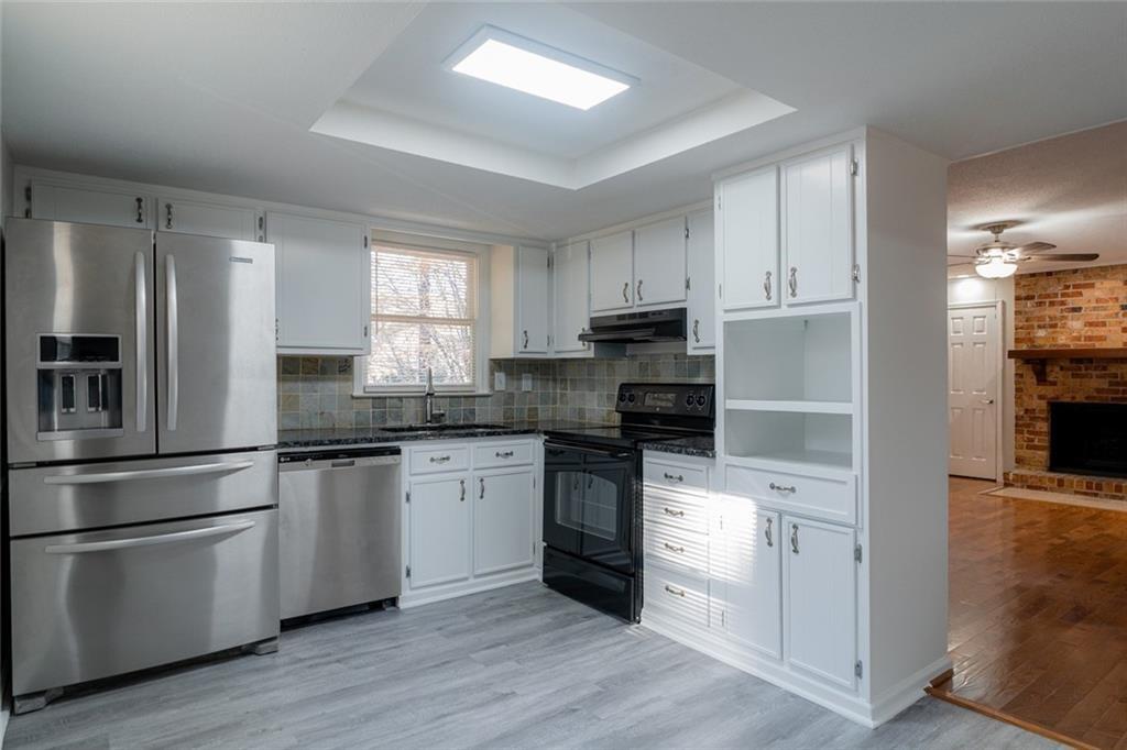 3599 Lower Roswell Road Marietta, GA 30068 - Photo 11 of 34 a kitchen with granite countertop white cabinets and stainless steel appliances