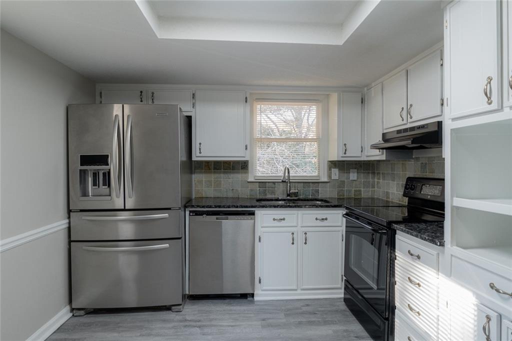 3599 Lower Roswell Road Marietta, GA 30068 - Photo 13 of 34 a kitchen with stainless steel appliances granite countertop a stove a refrigerator and a sink