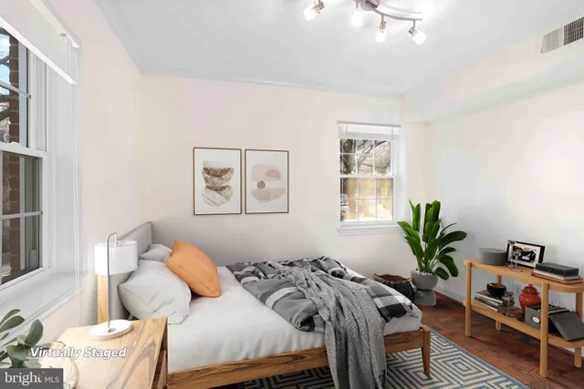 a bedroom with bed a potted plant and a window