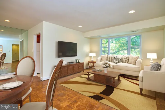 a living room with furniture a flat screen tv and a large window