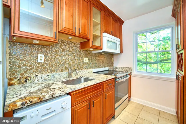 a kitchen with stainless steel appliances granite countertop a sink and a stove