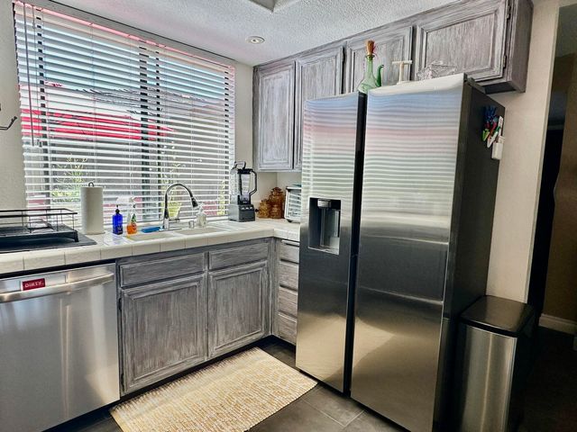 a kitchen with stainless steel appliances a refrigerator sink and cabinets