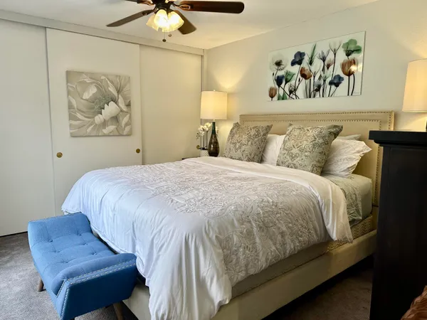 a bedroom with a bed and painting on the wall