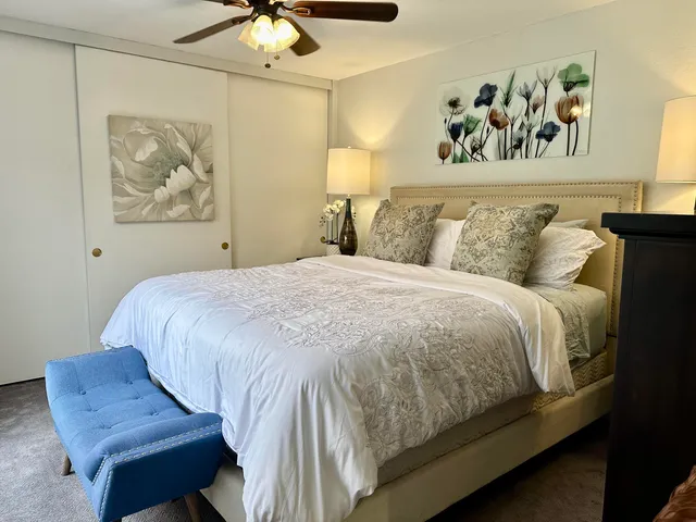 a bedroom with a bed and painting on the wall