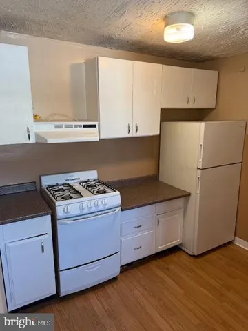 a kitchen with granite countertop a stove a refrigerator and a sink