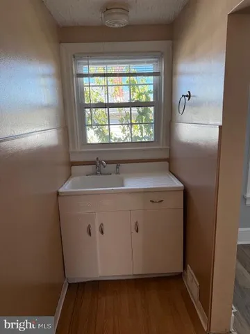 a view of a sink a window and cabinets