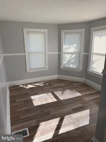 a view of a livingroom with wooden floor and a window
