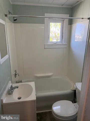 a white toilet sitting next to a bath tub