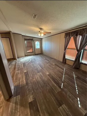 a view of empty room with wooden floor and window