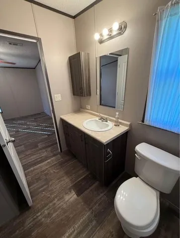 a bathroom with a toilet a sink and mirror