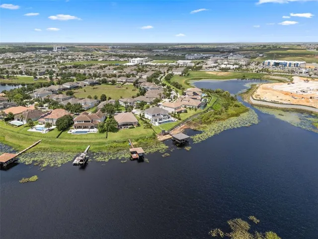 an aerial view of a city with lots of residential buildings ocean and mountain view in back