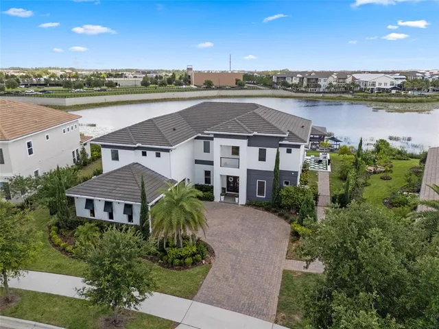 an aerial view of residential building with outdoor space and lake view in back