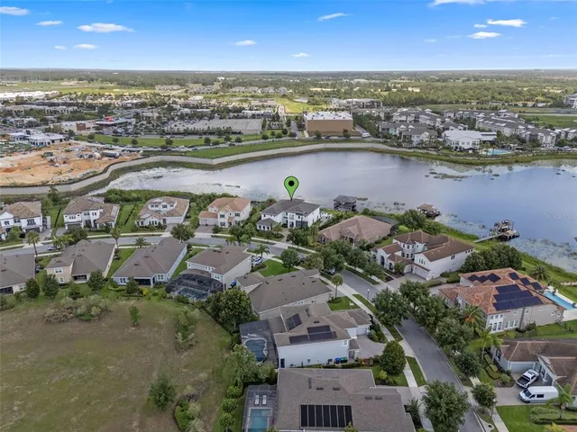 an aerial view of a city with lots of residential buildings ocean and mountain view in back