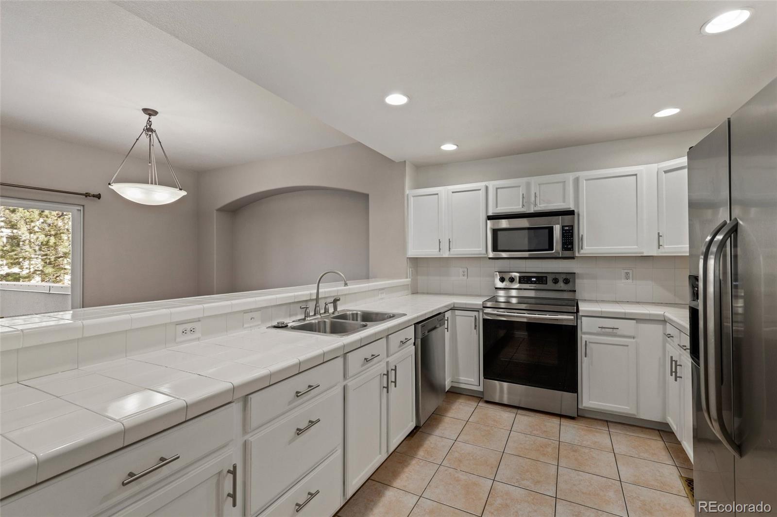 6677 South Forest Way, Unit D Centennial, CO 80121 - Photo 14 of 35 a kitchen with stainless steel appliances a sink stove and refrigerator
