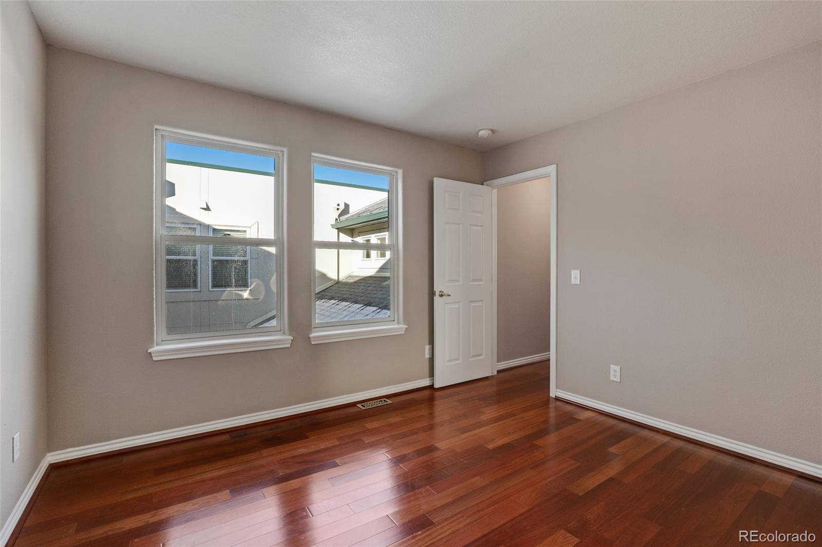 6677 South Forest Way, Unit D Centennial, CO 80121 - Photo 27 of 35 a view of an empty room with wooden floor and a window