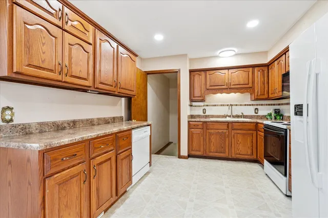 a kitchen with stainless steel appliances granite countertop a refrigerator stove top oven and sink