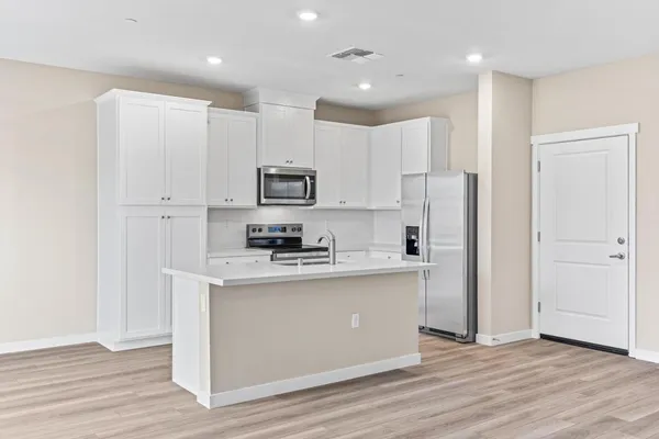 a kitchen with white cabinets and stainless steel appliances