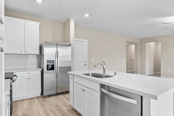 a kitchen with stainless steel appliances a refrigerator sink and microwave