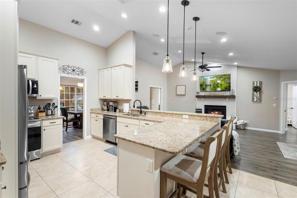 1777 Seneca Boulevard Winter Springs, FL 32708 - Photo 18 of 42 a kitchen with kitchen island granite countertop a stove a sink a oven a dining table and chairs