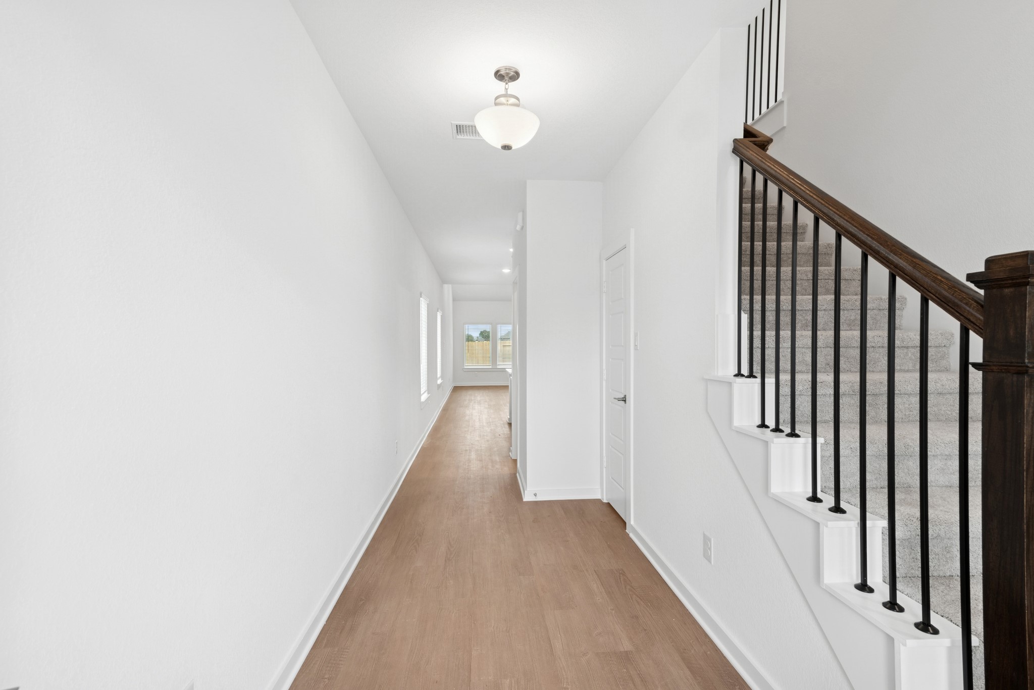 32503 Midsummer Drive Fulshear, TX 77441 - Photo 13 of 48 a view of a hallway with wooden floor and staircase