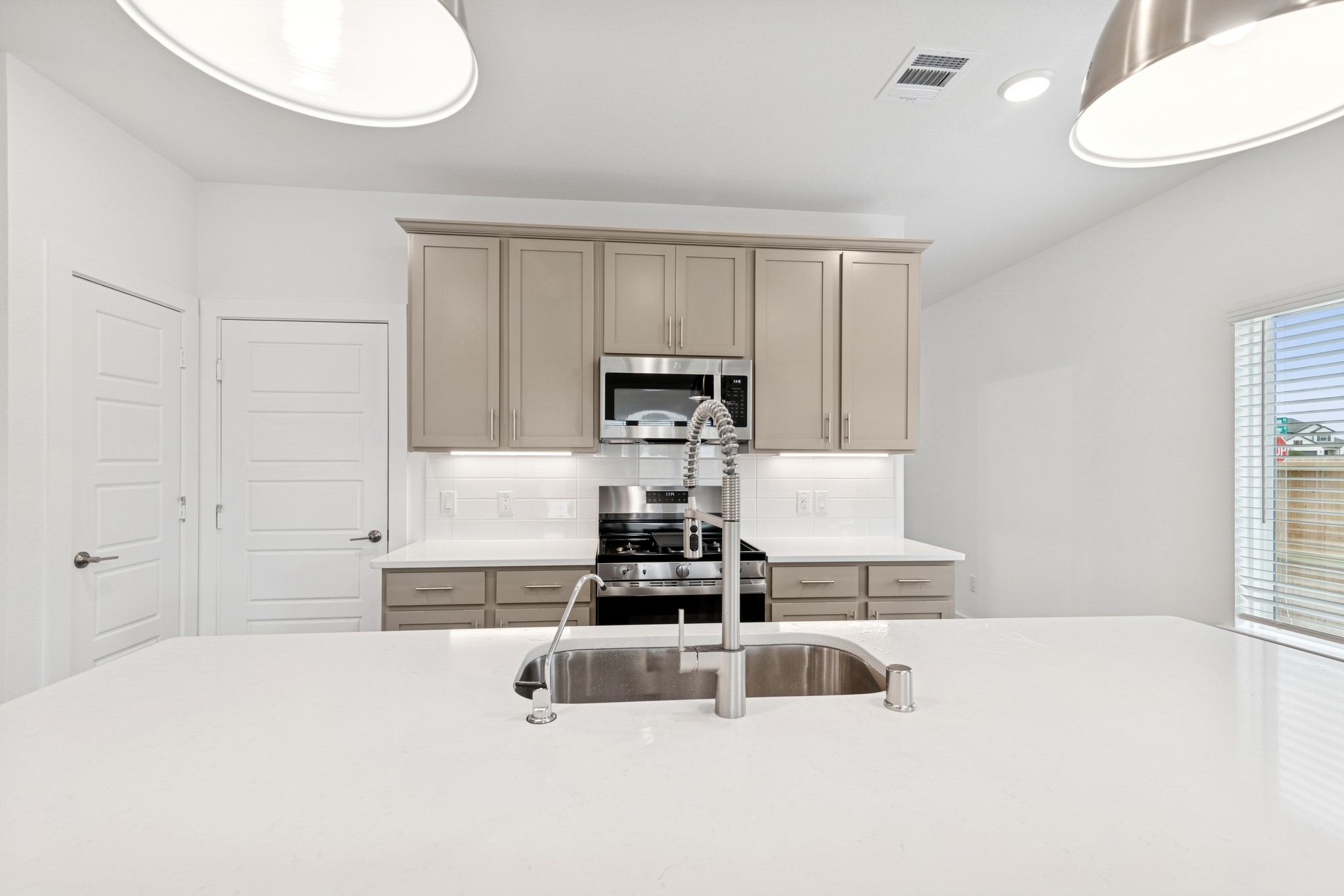32503 Midsummer Drive Fulshear, TX 77441 - Photo 17 of 48 a kitchen with kitchen island a stove a sink and a refrigerator