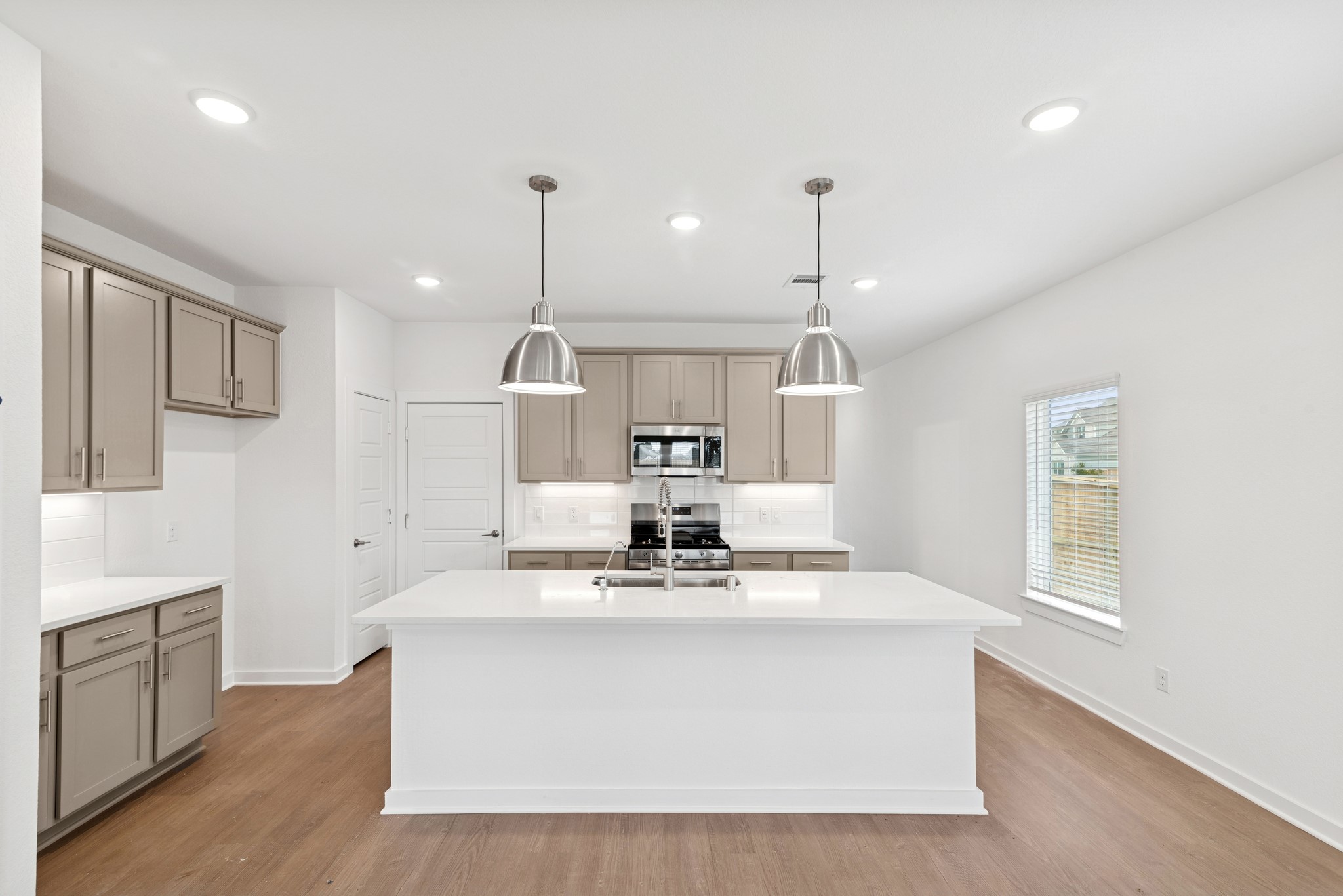 32503 Midsummer Drive Fulshear, TX 77441 - Photo 2 of 48 a view of kitchen with kitchen island stainless steel appliances a sink and living room view