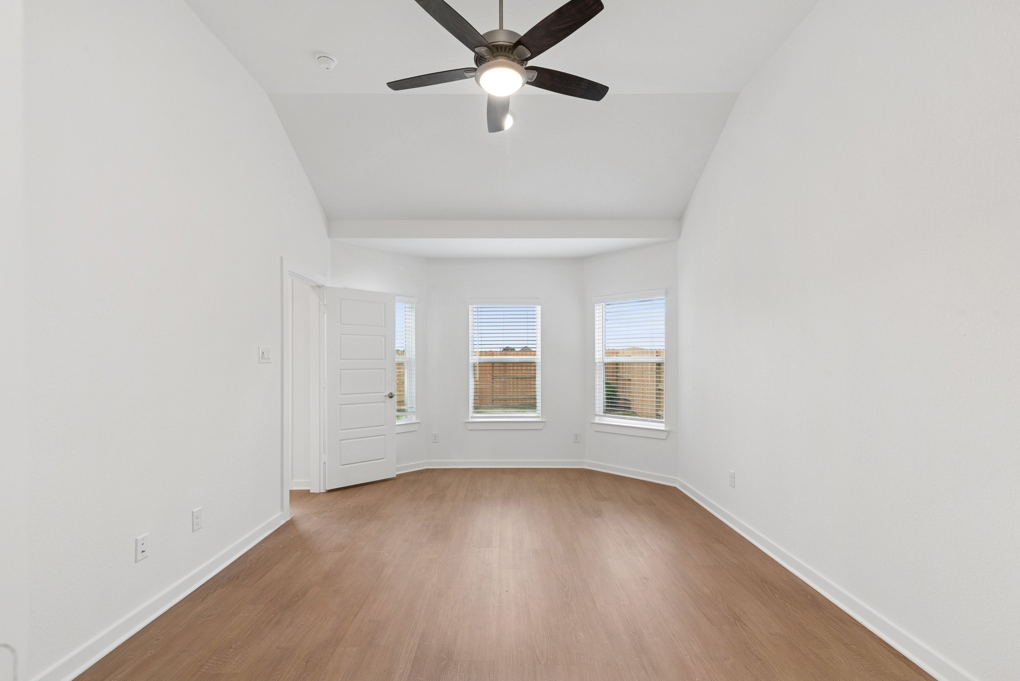 32503 Midsummer Drive Fulshear, TX 77441 - Photo 4 of 48 an empty room with wooden floor ceiling fan and windows