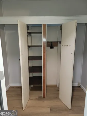 a view of walk in closet with empty racks