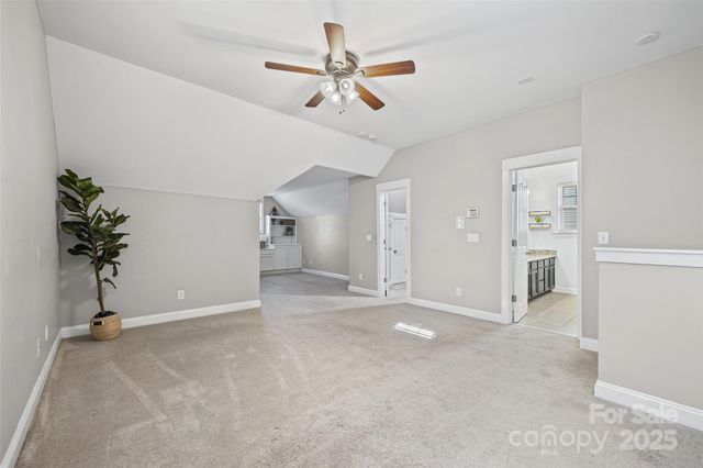 a view of a livingroom with a potted plant a ceiling fan and wooden floor