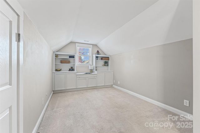 a view of a kitchen with white cabinets and wooden floor