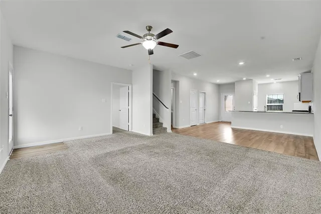 a view of an empty room and kitchen view