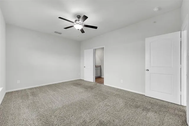 a view of an empty room with a ceiling fan