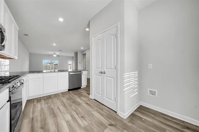 a kitchen with white cabinets and white appliances