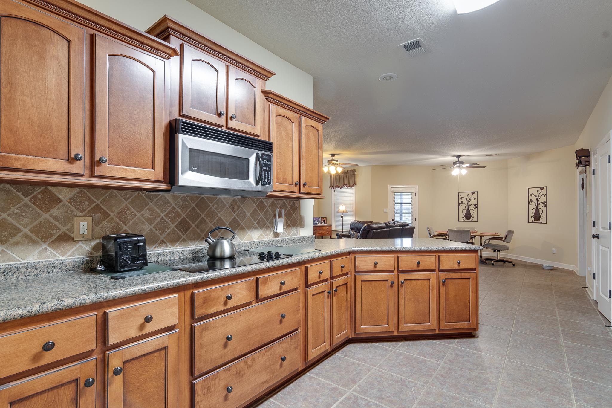 5350 Evergreen Road Lakeland, TN 38002 - Photo 15 of 24 Kitchen with ceiling fan, light tile patterned floors, black electric stovetop, and tasteful backsplash