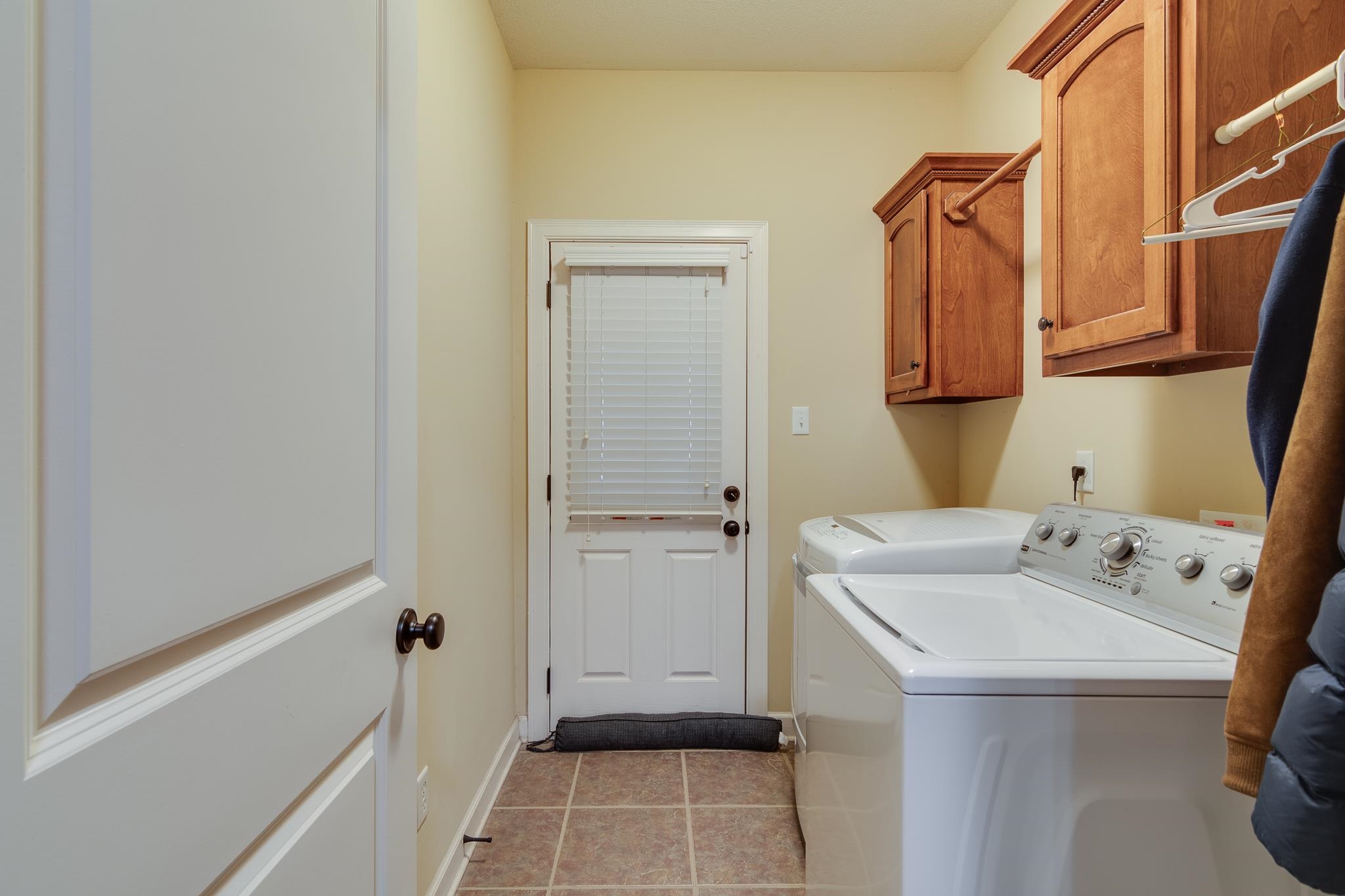 5350 Evergreen Road Lakeland, TN 38002 - Photo 17 of 24 Laundry room with washer and clothes dryer, light tile patterned floors, and cabinets