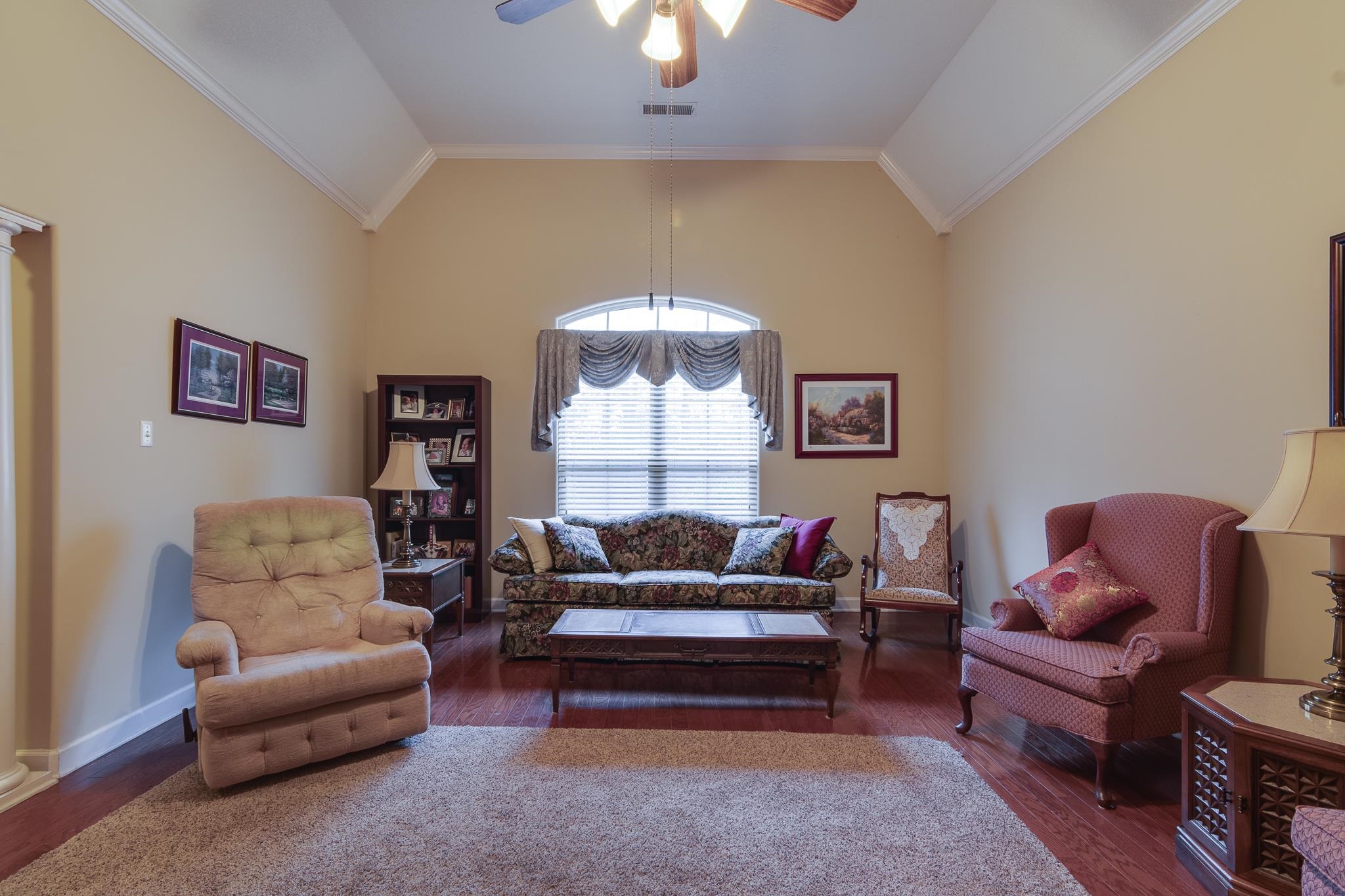 Living room featuring vaulted ceiling and dark wood-type flooring