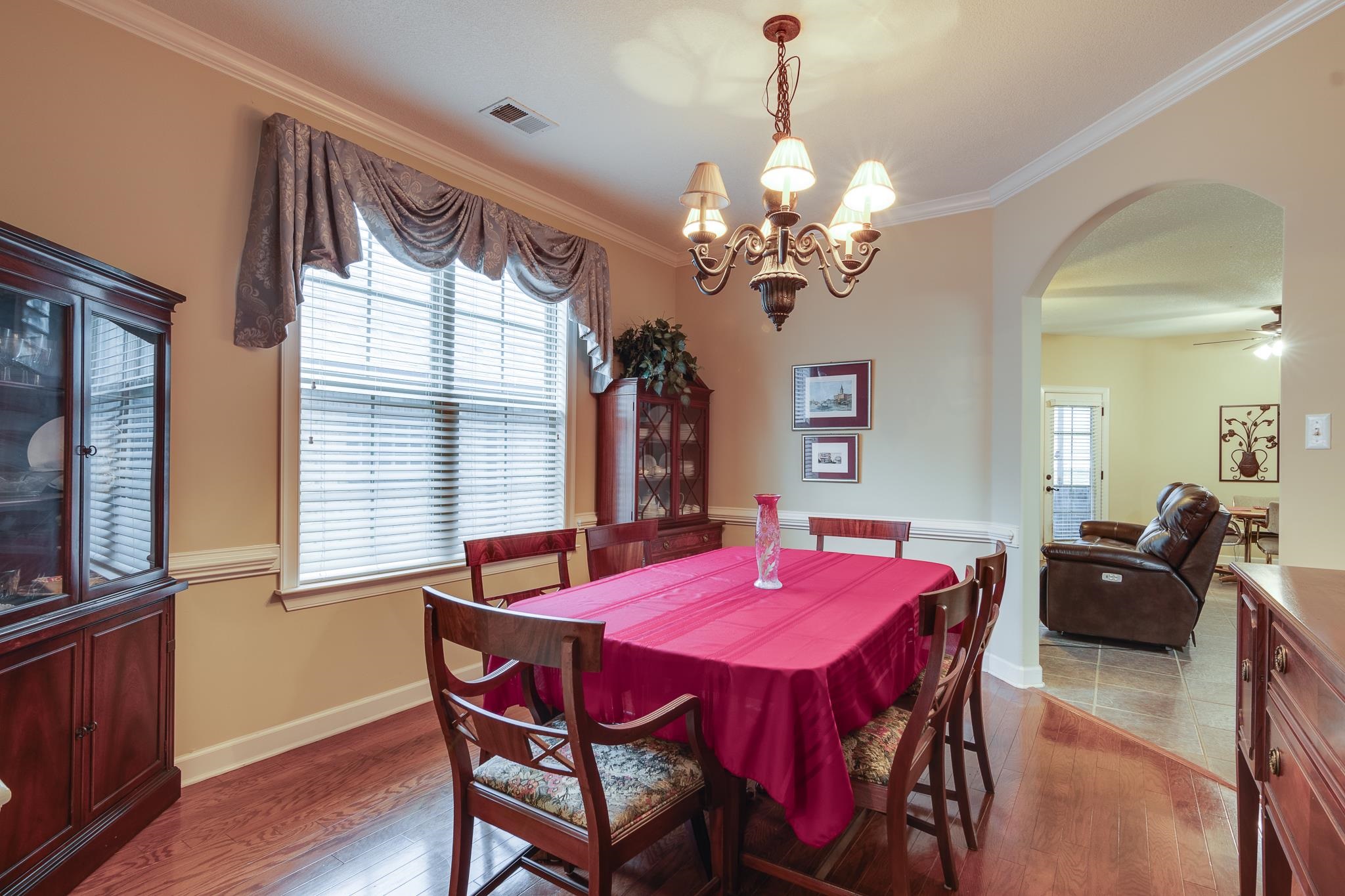 Dining room featuring hardwood / wood-style floors, ceiling fan with notable chandelier, and crown molding