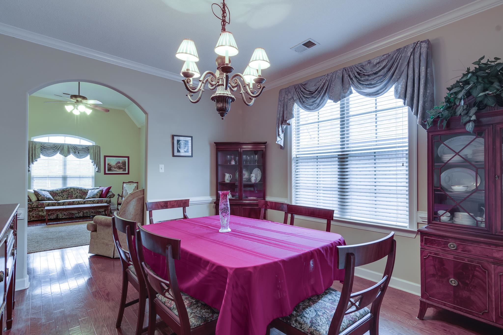5350 Evergreen Road Lakeland, TN 38002 - Photo 8 of 24 Dining area with crown molding, wood-type flooring, and ceiling fan with notable chandelier