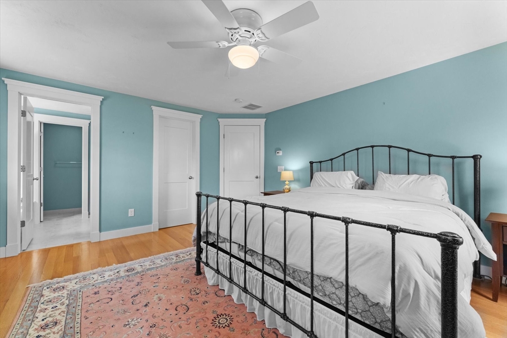 50 Quabbin Path Sutton, MA 01590 - Photo 24 of 42 a bedroom with a bed and a chandelier