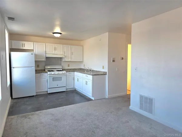 a kitchen with granite countertop white cabinets and white appliances