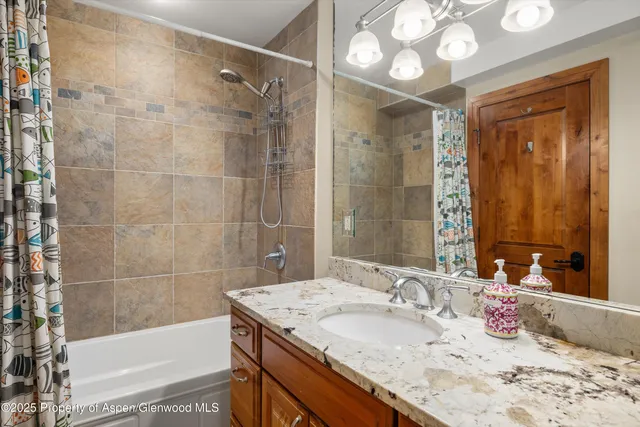 a bathroom with a granite countertop sink a toilet and shower