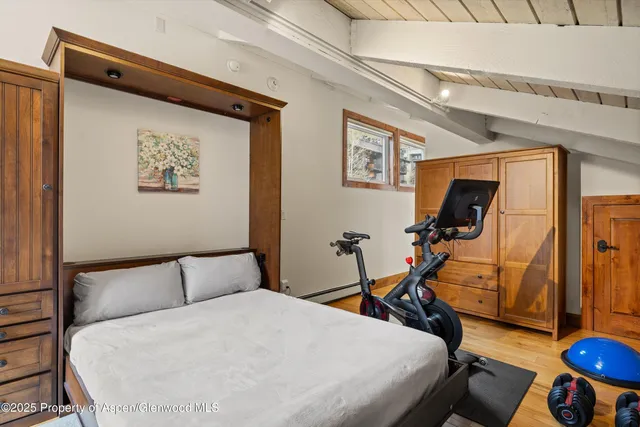 a bedroom with bed and wooden floor