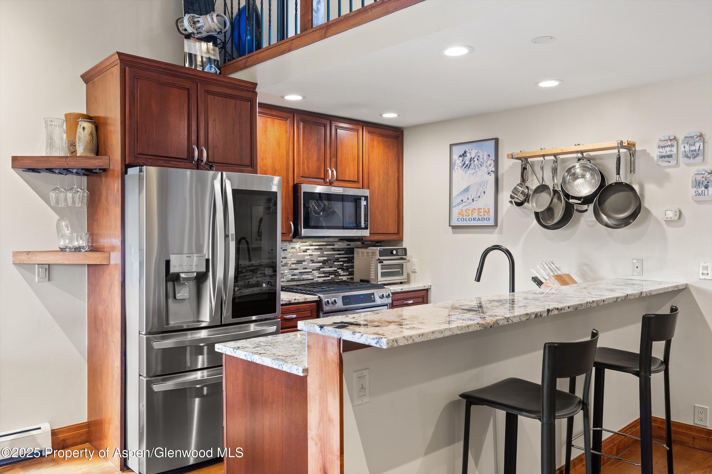 35 Lower Woodbridge Road, Unit W 184 Snowmass Village, CO 81615 - Photo 7 of 32 a kitchen with stainless steel appliances granite countertop a refrigerator and a stove top oven