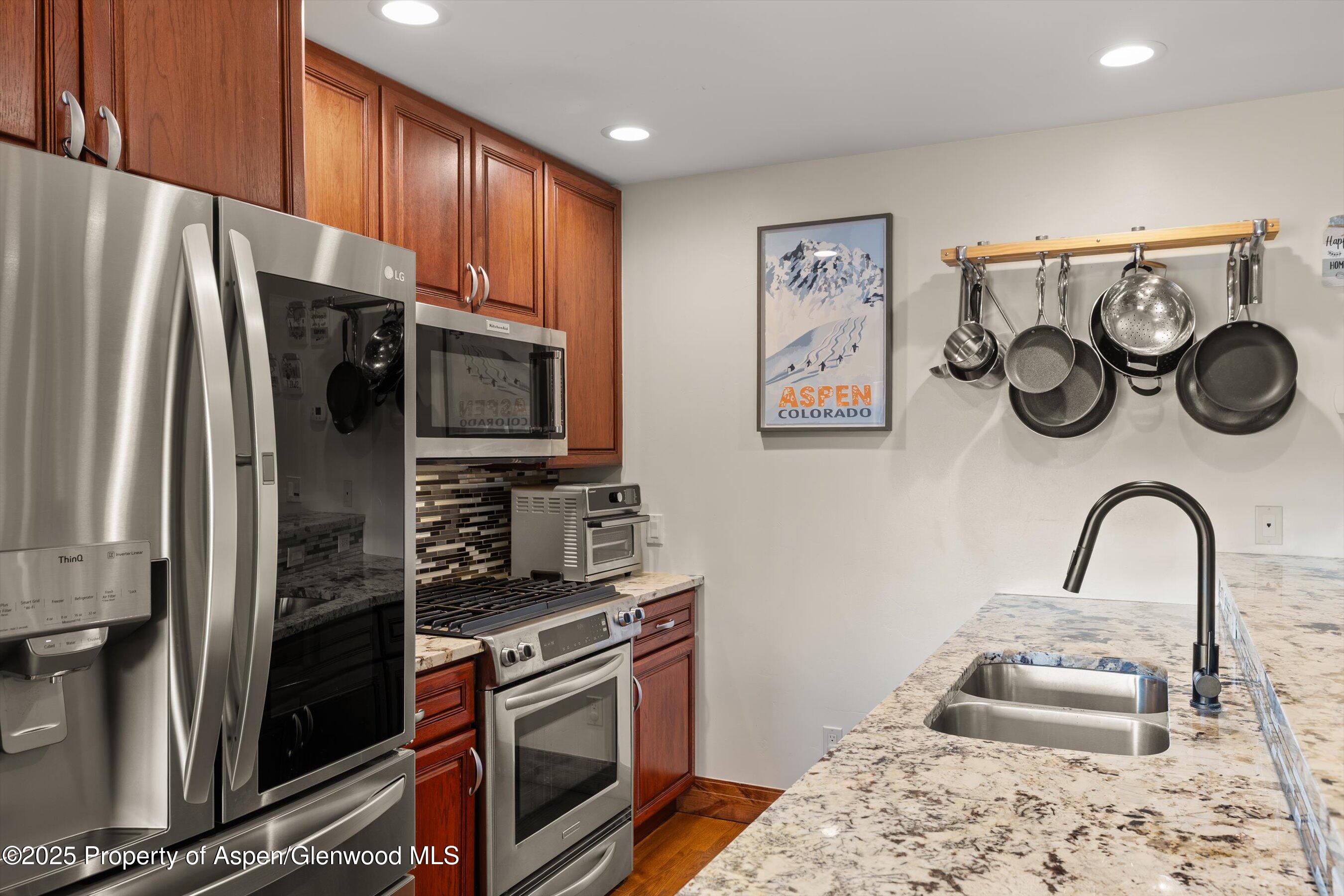 35 Lower Woodbridge Road, Unit W 184 Snowmass Village, CO 81615 - Photo 8 of 32 a kitchen with stainless steel appliances granite countertop a refrigerator and a stove top oven